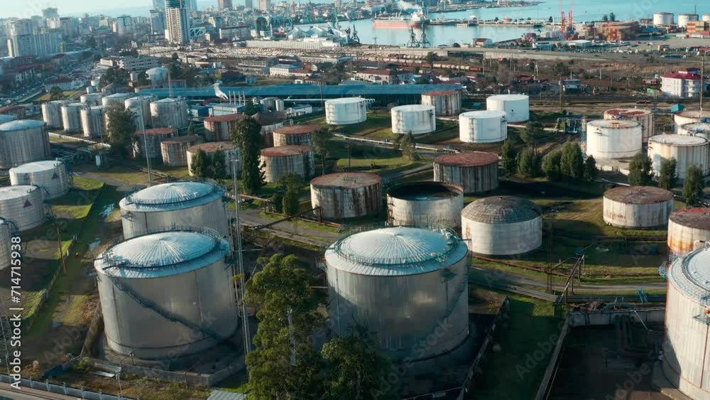 Aerial view of oil and gas terminal with steel storage tanks of oil and LPG petrochemical. Oil tank farm for gas, diesel and petroleum in a sea port near industrial plant and chemical rafinery Aerial view of oil and gas terminal with steel storage tanks of oil and LPG petrochemical. Oil tank farm for gas, diesel and petroleum in a sea port near industrial plant and chemical rafinery