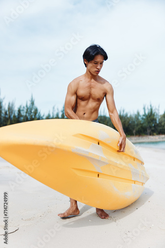 Happy Asian Man Enjoying Kayaking Adventure on Tropical Beach © SHOTPRIME STUDIO