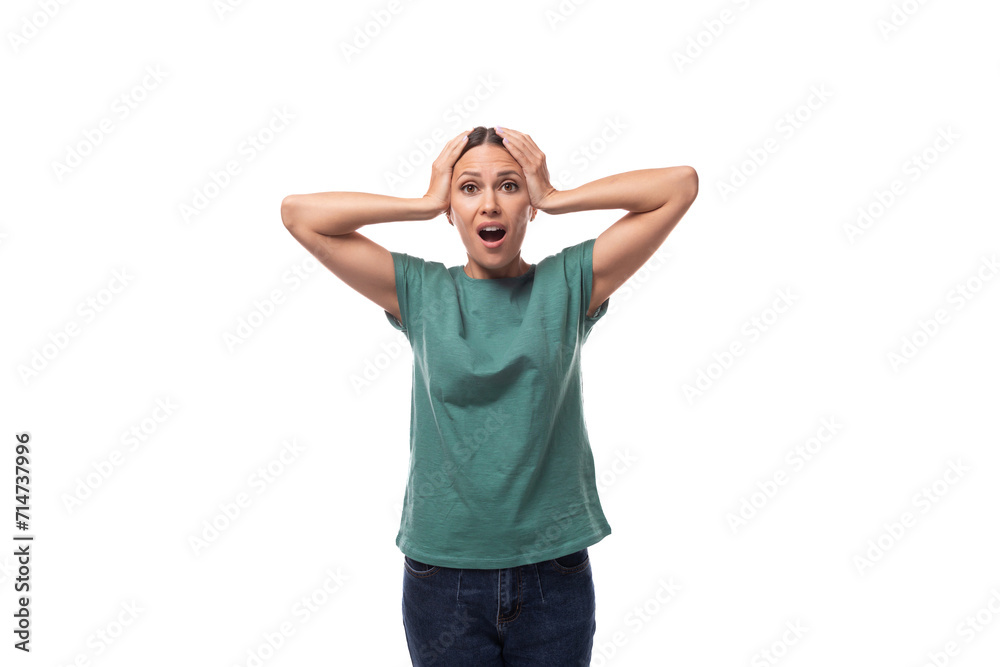 30 year old slender European brunette woman with a ponytail dressed in a green T-shirt and jeans looks at the camera with surprise 30 year old slender European brunette woman with a ponytail dressed in a green T-shirt and jeans looks at the camera with surprise