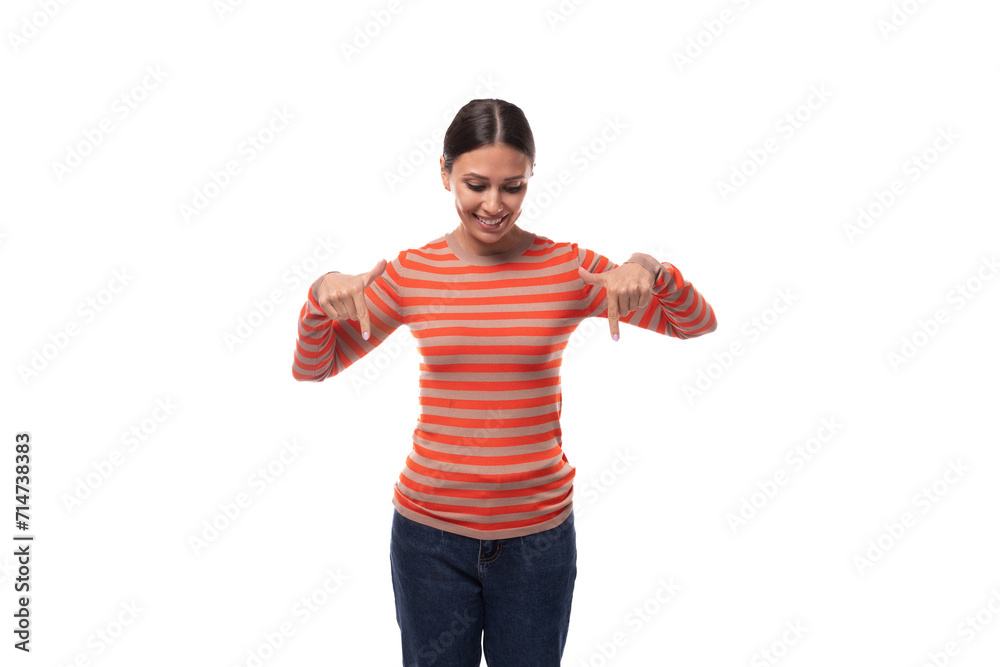 young brunette European slender woman dressed in a casual orange blouse and jeans draws attention pointing with her hands young brunette European slender woman dressed in a casual orange blouse and jeans draws attention pointing with her hands