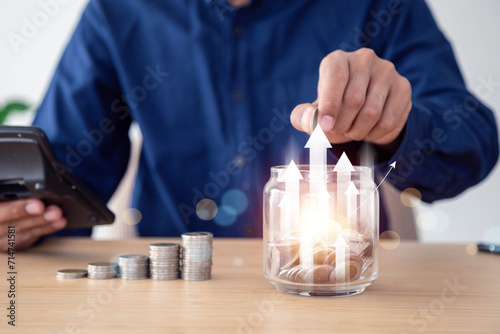 Man saving money concept. hand holding coins putting in jug glass , Planning step up, saving money for future plan, retirement fund , Concept business finance saving money and investment.