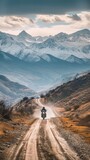 Aeriel view of a man riding a motorcycle bike on a mountainous valley road