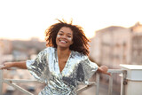 Young happy glamour african american woman with glitter on face standing on roof terrace outdoors