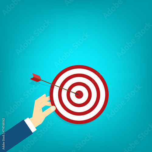 Hand holding a target, showing a goal. Red arrow hits the center. Business challenge failure and success concept. 