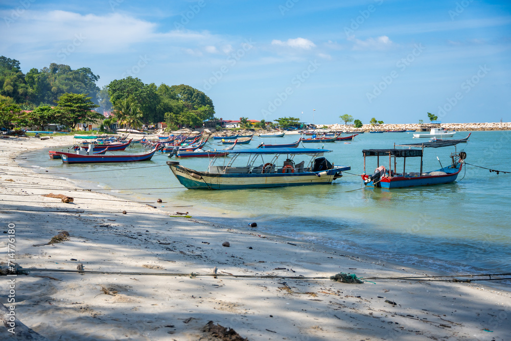 Naklejka premium Fishing boats on the sea and beach of George Town city in the distance on the Strait of Malacca in Penang, Malaysia.