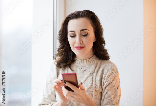 Cute trendy brunette female using mobile phone