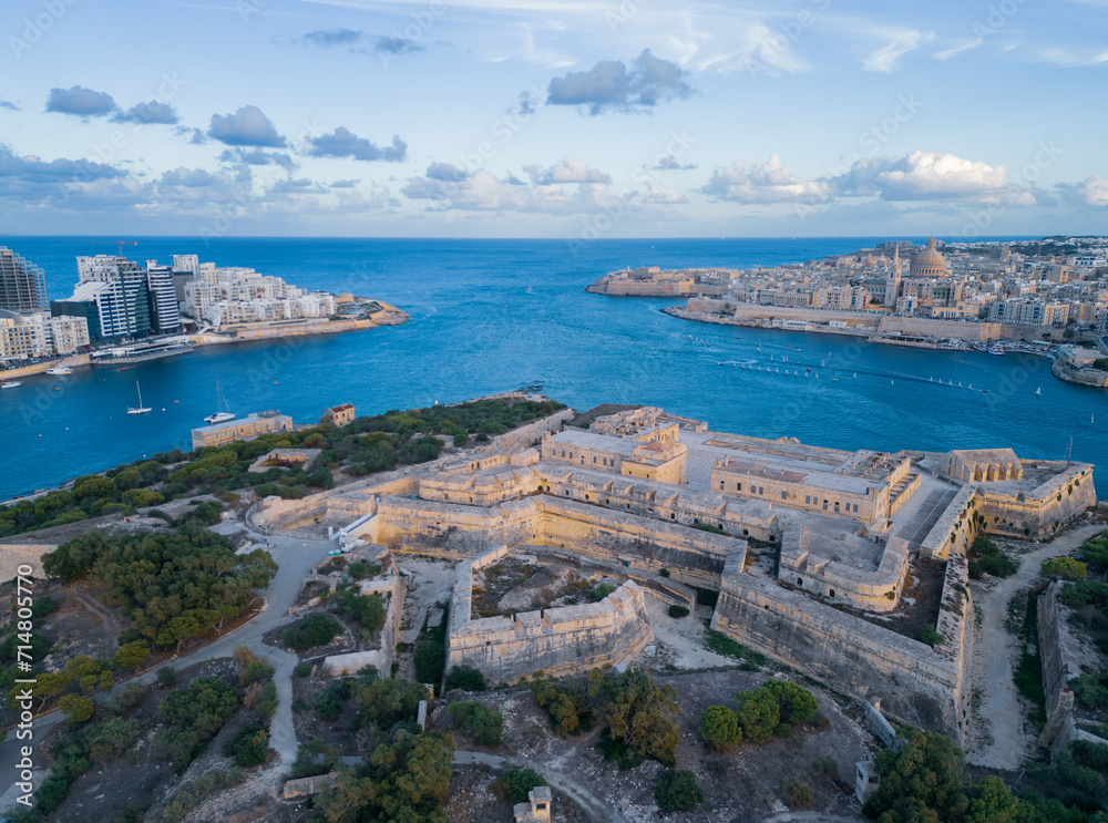 Fort Manoel at sunset aerial view on Valletta and Sliema from Manoel Island, Malta. Blue sky with clouds.