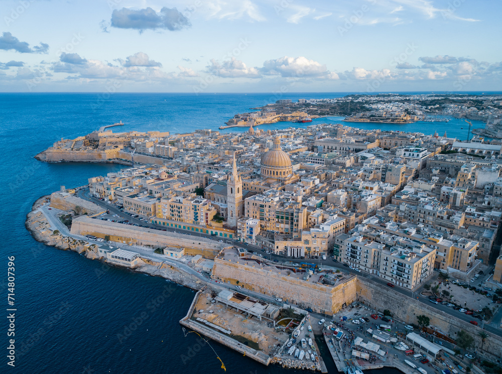Beautiful Valletta old town with cathedral at sunset.  Aerial view on historic buildings from harbor.
