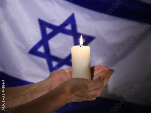 Flag of Israel and burning candle on black background. photo