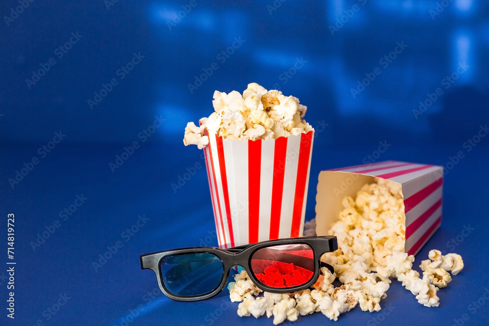 A banner for the film industry. A romantic movie date. A movie camera, 3D glasses, popcorn in striped cups on a blue background. The premiere of the film.