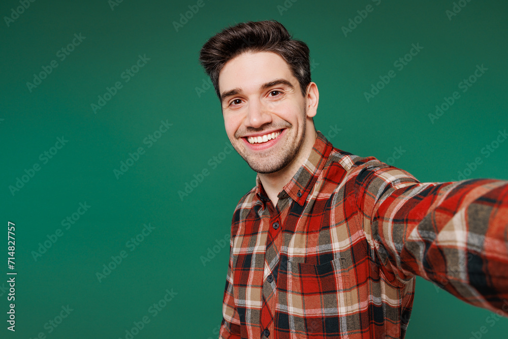 Young employee laborer handyman man wear red shirt do selfie shot on mobile cell phone isolated on plain green background. Instruments accessories for renovation apartment room. Repair home concept. Young employee laborer handyman man wear red shirt do selfie shot on mobile cell phone isolated on plain green background. Instruments accessories for renovation apartment room. Repair home concept.