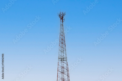 Internet signal tower or mobile phone signal tower isolated on blue sky background texture. Global communication and internet network connection concep