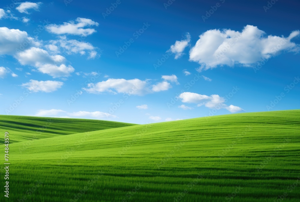 Rolling green hills beneath a brilliant blue sky adorned with fluffy clouds. Rolling green hills beneath a brilliant blue sky adorned with fluffy clouds.