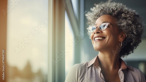 African middle age business woman looking at the window  © Krtola 