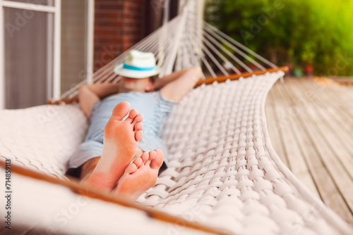 Man in hat in a hammock on a summer day photo