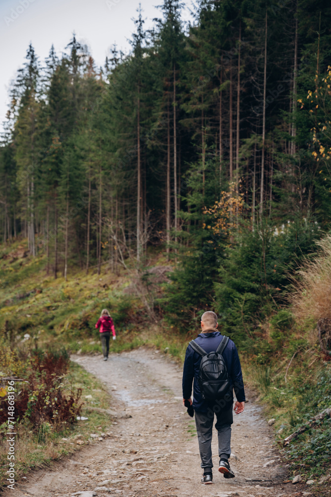 Fototapeta premium three friends are traveling in the mountains. overcome the route in the mountains with a backpack. autumn landscapes. Carpathian mountains. go on a hike with friends