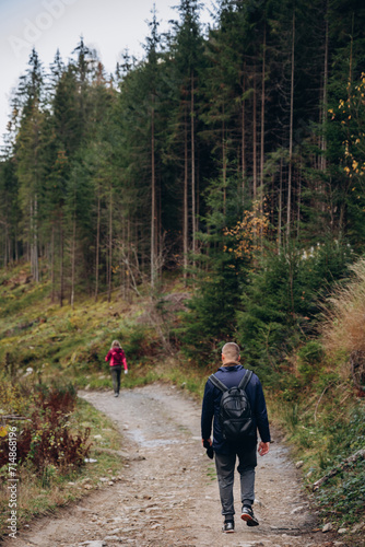 three friends are traveling in the mountains. overcome the route in the mountains with a backpack. autumn landscapes. Carpathian mountains. go on a hike with friends