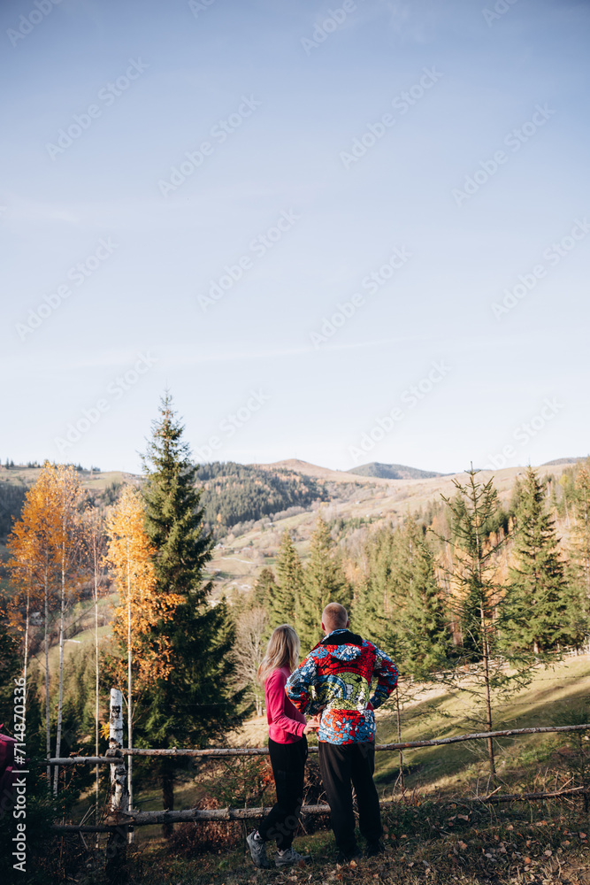 family young couple in the mountains, autumn forest. a man and a woman went to the mountains. clothes and shoes for trekking. Man and a woman went on a mountain trip. CARPATHIAN MOUNTAINS
