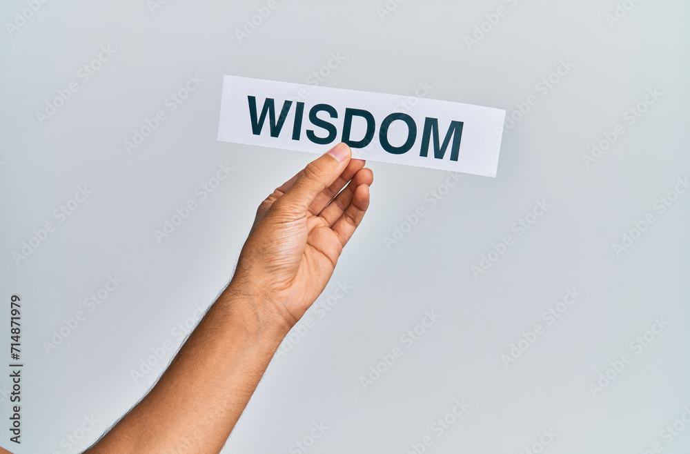 Hand of caucasian man holding paper with wisdom word over isolated white background Hand of caucasian man holding paper with wisdom word over isolated white background