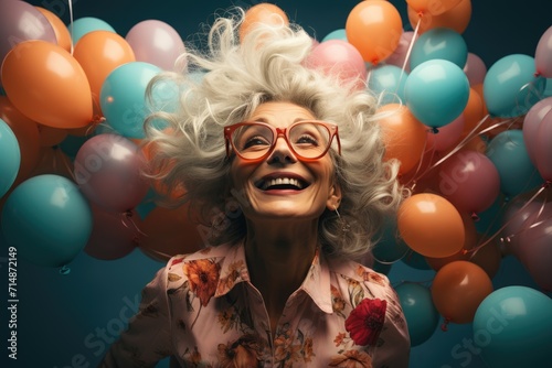 A beaming woman, adorned with glasses and a colorful bouquet of balloons, radiates joy and exuberance as she prepares for a festive celebration photo
