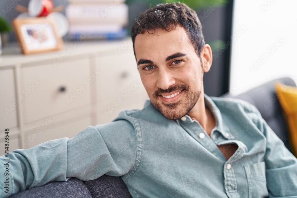 Young hispanic man smiling confident sitting on sofa at home Young hispanic man smiling confident sitting on sofa at home
