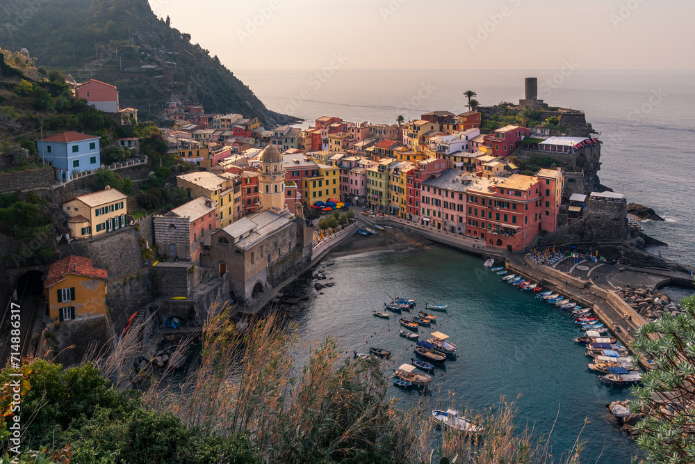 Mediterranean town on rocky coast of Cinque Terre with colorful buildings at sunrise, Vernazza, Italy