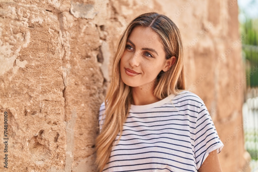 Young blonde woman smiling confident looking to the side at street