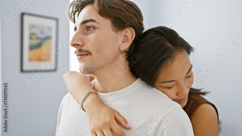 Intimate portrait of a loving interracial couple in a cozy indoor setting, featuring a man and woman embracing. © Krakenimages.com