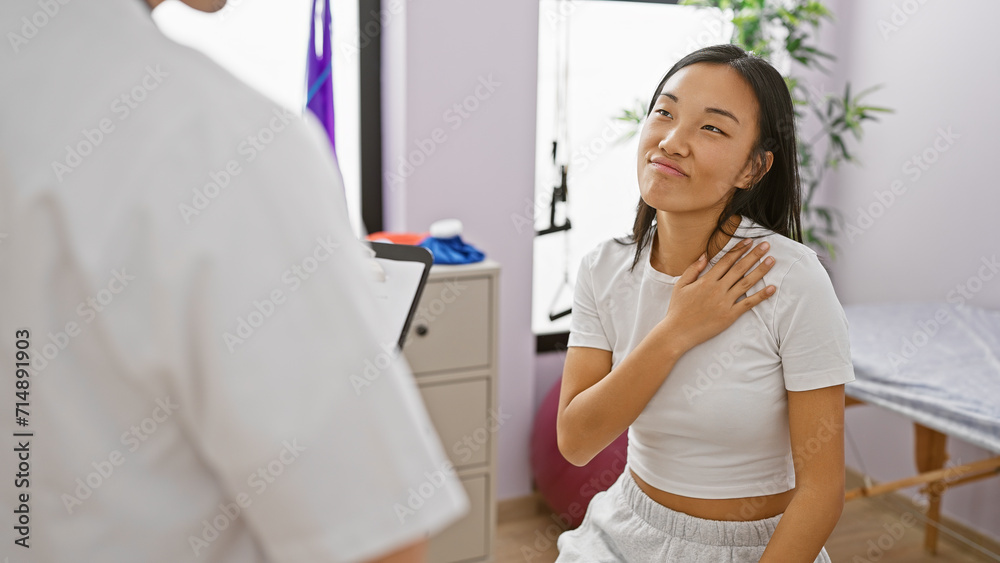 A woman patient expressing discomfort to a doctor at a physiotherapy session indoors. A woman patient expressing discomfort to a doctor at a physiotherapy session indoors.