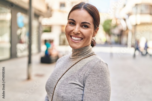 Young beautiful hispanic woman smiling confident standing at street photo