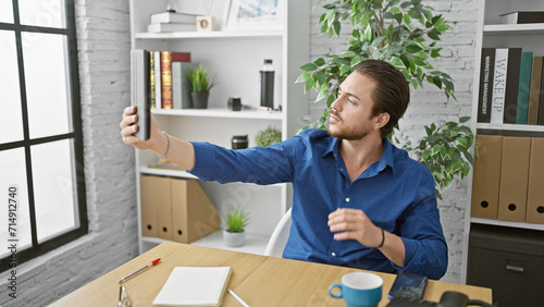 Young hispanic man business worker make selfie by touchpad at the office