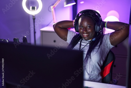 African american woman streamer smiling confident relaxed with hands on head at gaming room