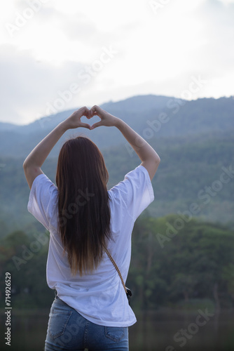 woman raised her hands and made heart symbol to express meaning of love friendship and kindness to her friends and lovers. woman uses her hands to make a heart symbol that means love and friendship.