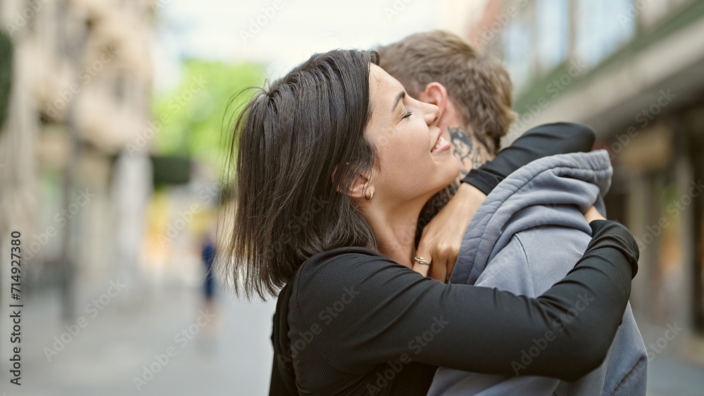 Obraz premium Beautiful couple smiling confident hugging each other at street