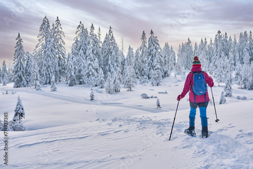 nice and active senior woman hiking with snow shoes in deep powder snow in the  Hochhaedrich area of Bregenz Forest in Vorarlberg, Austria photo