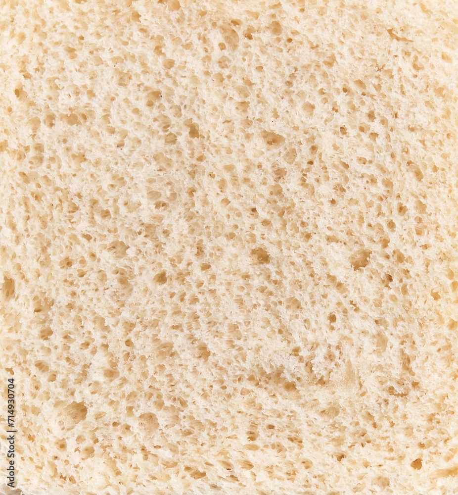 Close-up texture of a slice of white bread, showcasing its porous surface and soft appearance.