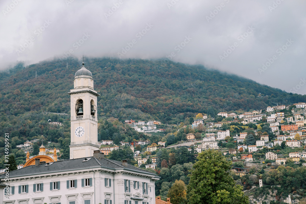High bell tower near an ancient villa in the town of Cernobbio at the foot of the mountains. Como, Italy