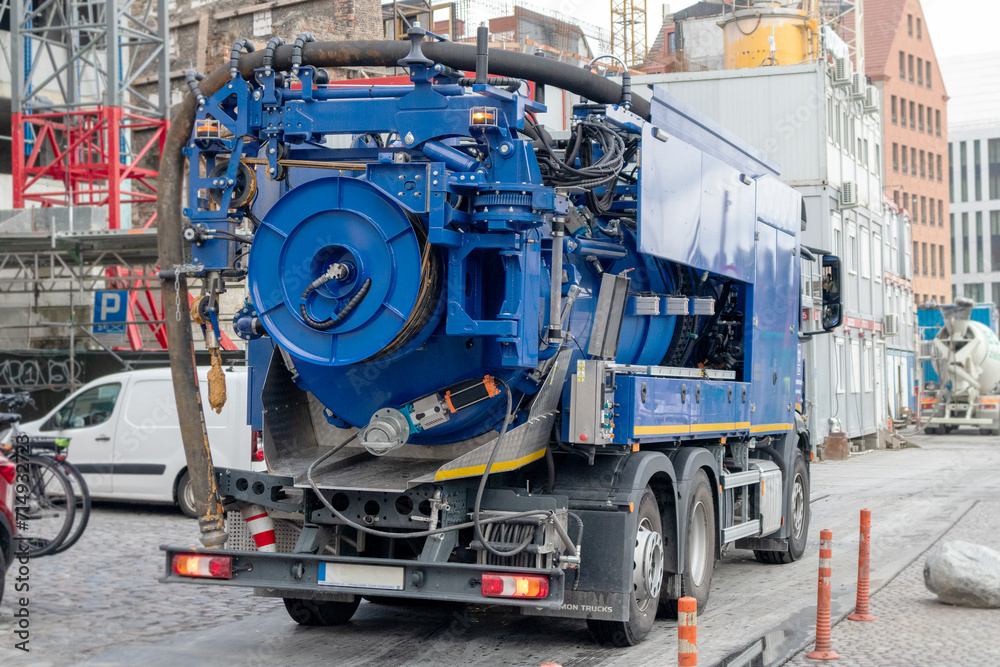 A large blue truck on a stone pavement with buildings in the background
A large blue truck on a stone pavement with buildings in the background