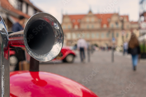 
metal horn on red car fender on background of city streets