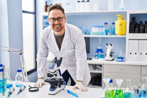 Young caucasian man scientist smiling confident standing at laboratory