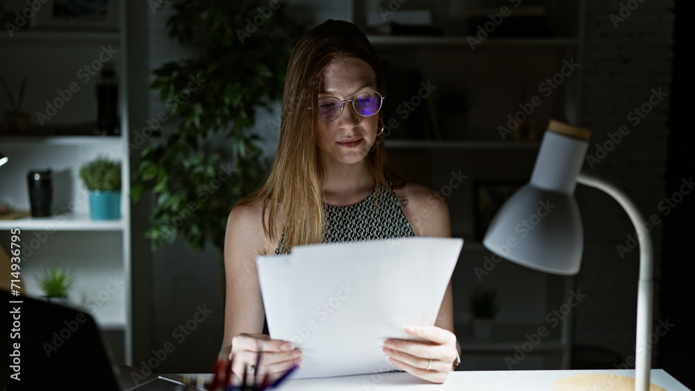Young blonde woman business worker reading document working at the office