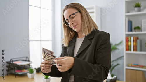Canvas Print Attractive young blonde business woman in glasses brimming with happiness as she