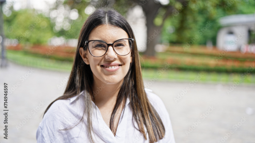 Young beautiful hispanic woman wearing glasses smiling happy in the streets of Madrid