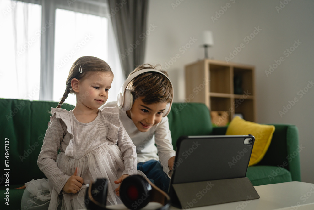 Brother sister siblings use digital tablet at home watch online video