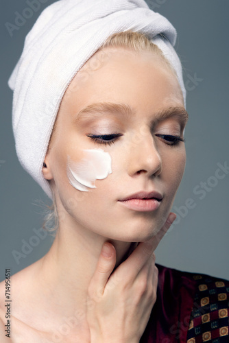 Girl in a towel on her head  pajamas and cream on her face