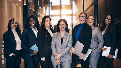 Diverse group of diverse businesswomen laughing in an office lobby photo