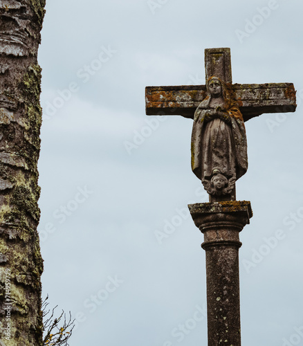 Bild auf Leinwand Traditional stone cross sculpture with carved figure of the virgin Mary against