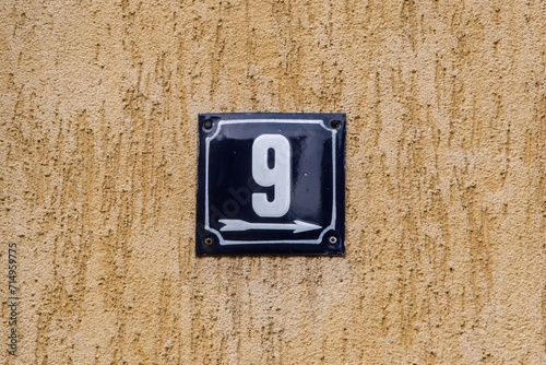 Weathered grunge square metal enameled plate of number of street address with number 9