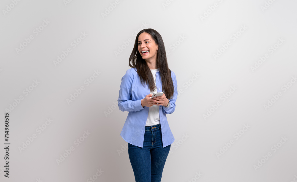 Laughing businesswoman texting over smart phone and looking away on isolated white background Laughing businesswoman texting over smart phone and looking away on isolated white background