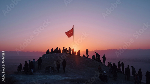 At the break of dawn, people gather on a hilltop to witness the raising of the Nowruz flag, a symbolic act heralding the arrival of the New Year. The early morning light and the fe photo